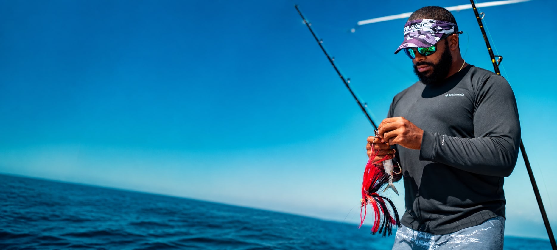 An angler rigging a skirted trolling lure on the boat off Belize