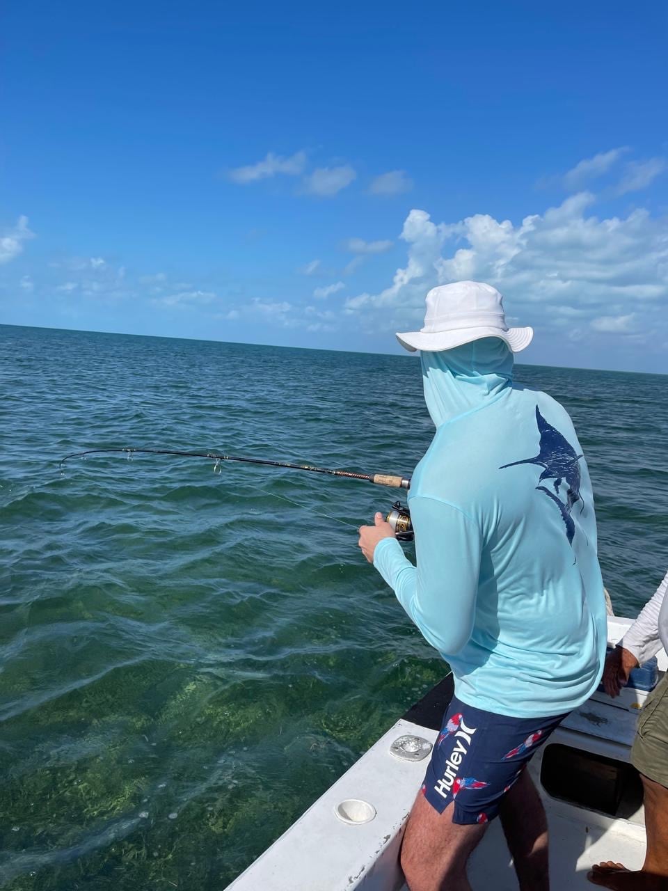 Angler casting from the boat over the flats off Belize